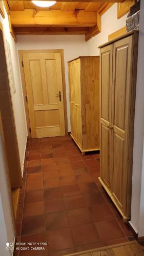 a hallway with wooden cabinets and a tiled floor at Samota u Hadince in Bartošovice v Orlických Horách
