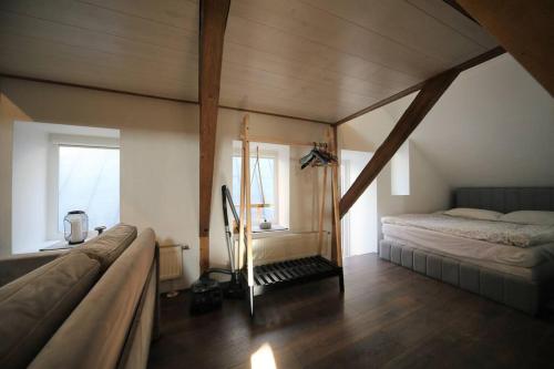 een slaapkamer op zolder met een bed en een raam bij 3 level apartment in Old Town / Riga in Rīga