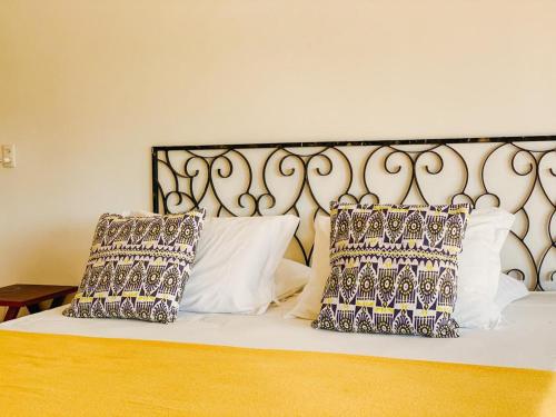 a large white bed with two pillows on it at Pousada Vayú in Icaraí