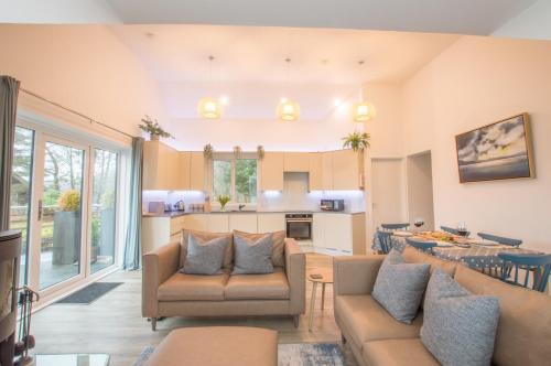 a living room with two couches and a kitchen at Harbour Master in Kilmelfort