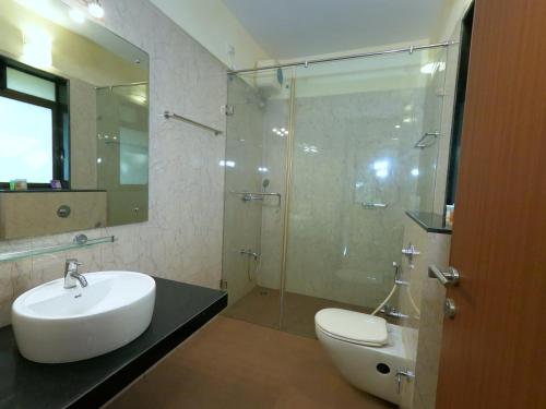 une salle de bain avec toilettes, lavabo et douche dans l'établissement Spacious 3BR Oasis with Wi-Fi short Drive to Panjim & Casinos C1-101, à Panaji