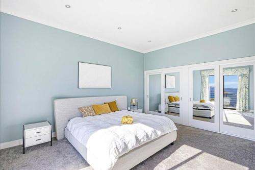 ein Schlafzimmer mit blauen Wänden und einem großen Bett in der Unterkunft Panoramic Mountain view house on 7ha of lands in Medlow Bath