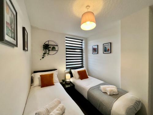 two beds in a small room with a window at Bramhall House - Tranquil Escape Hideaway in Cleethorpes