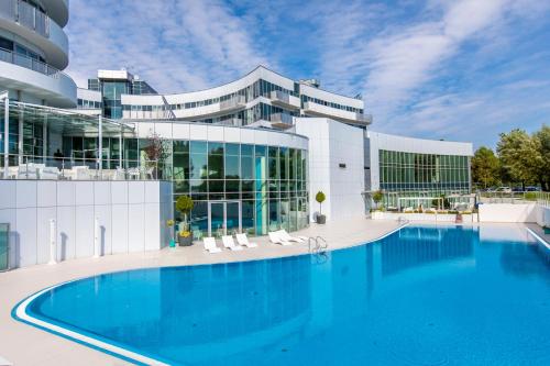 a large swimming pool in front of a building at Copernicus Toruń Hotel in Toruń