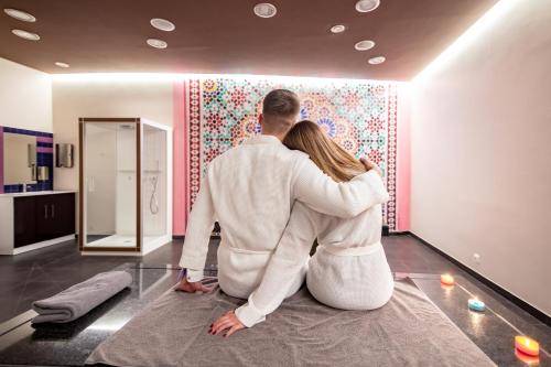 a man and woman sitting on the floor in a room at Copernicus Toruń Hotel in Toruń