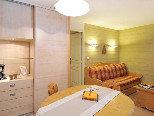 Cette petite chambre comprend une table et un canapé. dans l'établissement Appartement rénové skis aux pieds avec balcon - FR-1-181-2050, à La Plagne Tarentaise