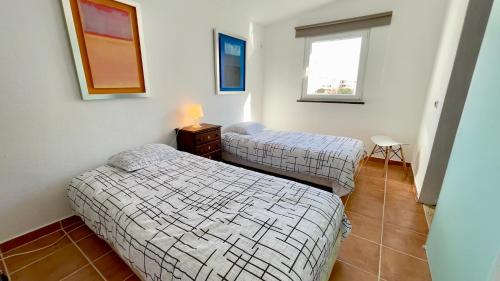 Zimmer mit 2 Betten, einem Tisch und einem Fenster in der Unterkunft Apartamento T2 com Terraço grande in Quarteira