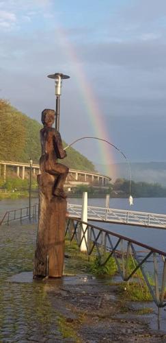 a statue of a man fishing with a rainbow in the background at Ferienwohnung Am Geysirzentrum in Andernach