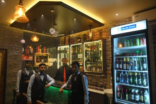a group of men standing in front of a bar at Hotel Surya Grande in Kudal