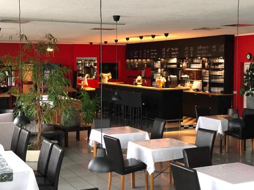 un restaurante con mesas y sillas y un bar en astral'Inn Leipzig Hotel & Restaurant, en Leipzig