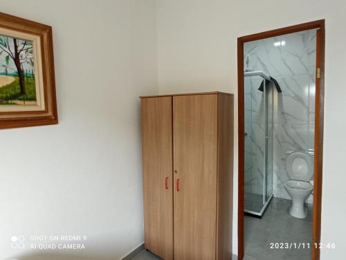 a bathroom with a wooden cabinet next to a toilet at Paraíso em Angra dos Reis in Angra dos Reis