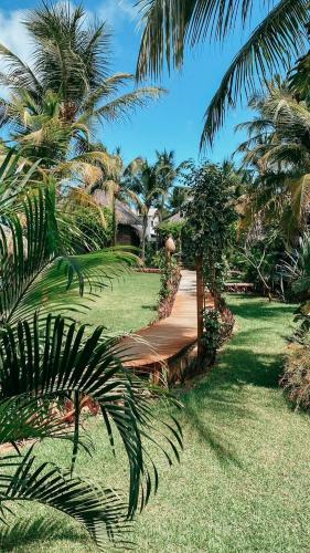 a walkway leading to a resort with palm trees at Pousada Vayú in Icaraí