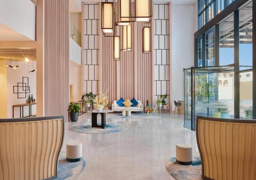 a lobby with chairs and tables in a building at voco Dubai The Palm by IHG in Dubai