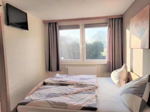 a bed sitting in a room with a window at Ferienwohnung 3 - a76814 in Groß Vollstedt