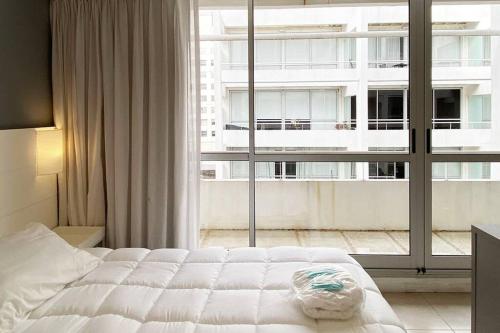 1 dormitorio con cama y ventana grande en BALC0511 Cómodo Monoambiente por San Telmo en Buenos Aires