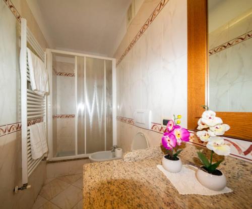łazienka z blatem z 2 wazami i kwiatami w obiekcie Le Palme w mieście Ospedaletti