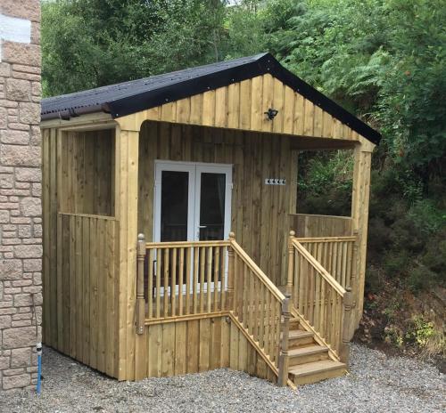 a wooden shed with a porch and a ramp at Carnach in Fort William