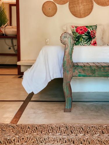 a wooden bed in a room with a white blanket at Pousada Vayú in Icaraí