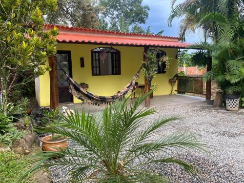 una casa amarilla con techo rojo en Vale da Paz en Guapimirim