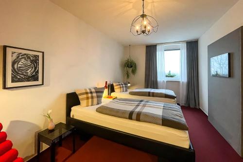 1 dormitorio con 2 camas y lámpara de araña en Pension Kirschberg, en Bretleben