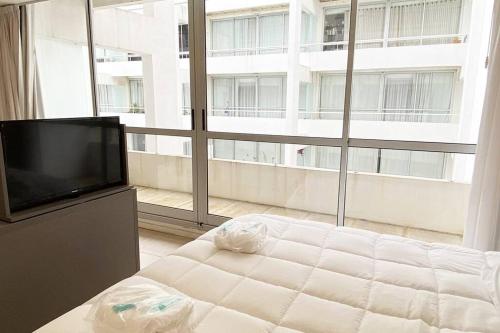 una camera da letto con televisore e ampia finestra di BALC0408 Excelente departamento Studio por San Telmo a Buenos Aires
