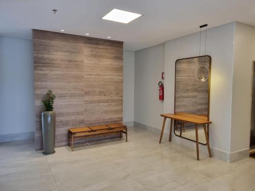 a lobby with a bench and a table and a mirror at Recanto do Bosque FLAT 205 in Caldas Novas