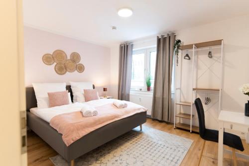 um quarto com uma cama, uma secretária e uma janela em DWELLSTAY - Premium Wohnung I 95qm I 3 Schlafzimmer I großes Bad I Küche I Wohnzimmer I TV em Fulda