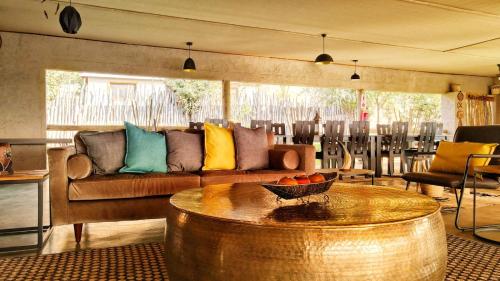 a living room with a couch and a table at Xhabe Safari Lodge Chobe in Muchenje