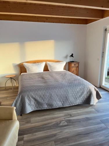 a bedroom with a large bed with a wooden headboard at Klosterblick in Inzigkofen