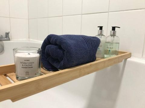 a wooden shelf with a blue towel and a candle at KB99 Comfy 2 Bedroom House in Horsham, pets very welcome with easy links to London and Gatwick in Roffey