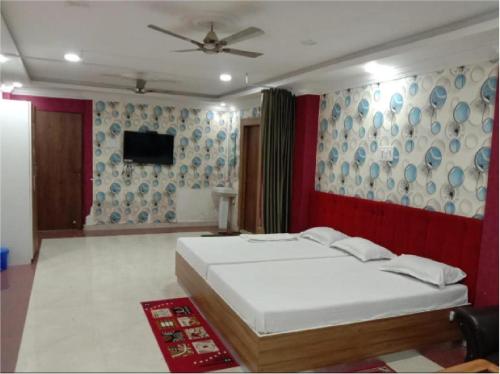 1 dormitorio con 1 cama y ventilador de techo en Hotel Geetanjali Buddha Resort By WB Inn en Bodh Gaya