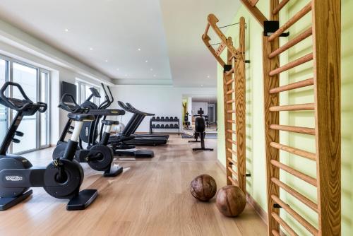 a fitness room with treadmills and exercise equipment at Mövenpick Hotel Stuttgart Messe & Congress in Stuttgart