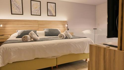um quarto com uma cama grande e toalhas em Ferrol Apart Hotel em Funes