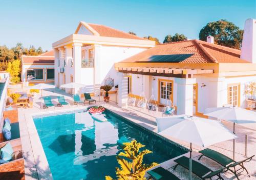 a villa with a swimming pool and a house at CLIFF Surf House in A dos Cunhados