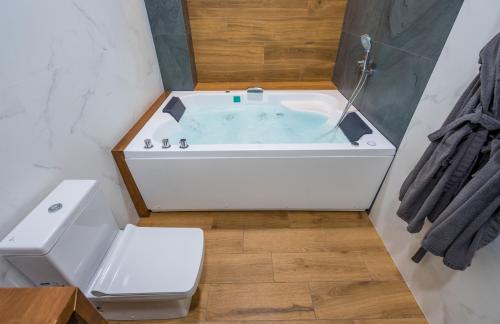 a bathroom with a bath tub with a toilet at Hotel City Lights - Tbilisi in Tbilisi City