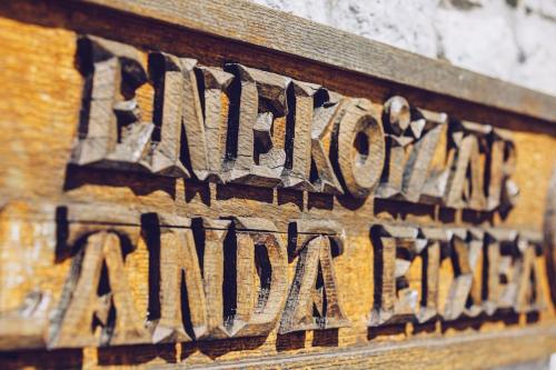 a wooden sign with the name of a istg at Casa rural Enekoizar in Abaurrea Alta