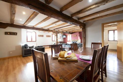 a dining room and living room with a table and chairs at Casa rural Enekoizar in Abaurrea Alta