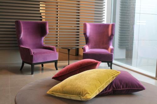 two purple chairs and a pillow in a room at Link124 Hotel in Parma