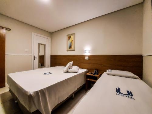 two beds in a hotel room with avertisement for at Hotel Itamarati Centro-República in Sao Paulo