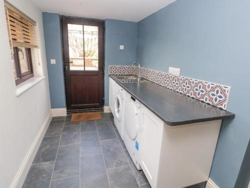 a laundry room with a sink and washing machines at Green Grove Barn in Carmarthen