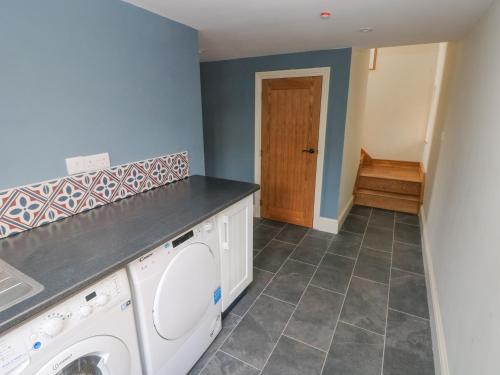 a laundry room with a washer and dryer at Green Grove Barn in Carmarthen