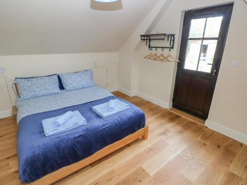 a bedroom with a bed with two towels on it at Green Grove Barn in Carmarthen