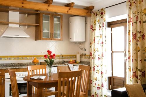 une cuisine avec une table et un vase de fleurs. dans l'établissement Casa Palacio Luna, à El Puerto de Santa María