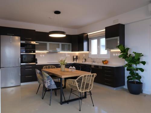 a kitchen with a table and chairs in a kitchen at Sea La Vie in Adelianos Kampos