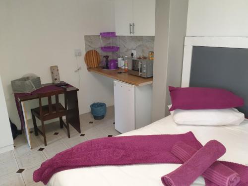 a bedroom with a bed with purple towels on it at The Haven: Make our Home your Home in Estcourt