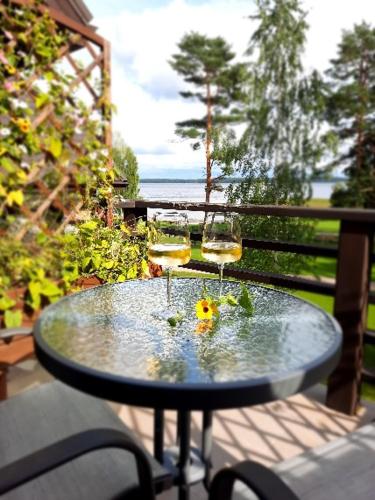 two glasses of wine sitting on a table on a balcony at Usmas muiža in Usma