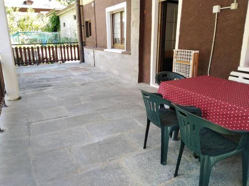 Millefiori house في Antronapiana: طاولة حمراء وكراسي على الفناء
