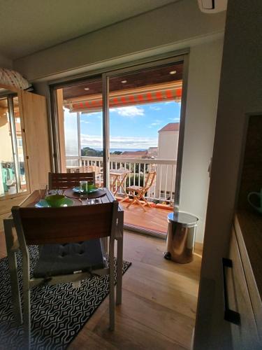 a dining room with a table and a view of a balcony at Studio Tout à Pied - Vue Sur Mer in Saint-Aygulf
