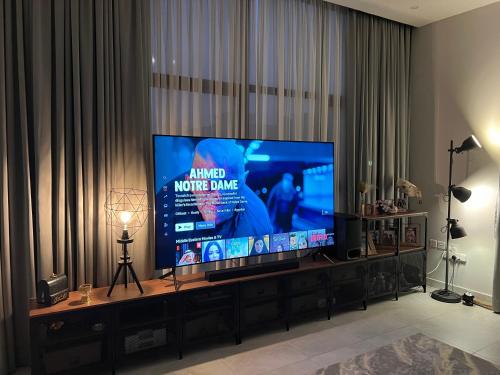 TV de pantalla plana grande en la sala de estar. en Casa Shakhbout, en Abu Dabi
