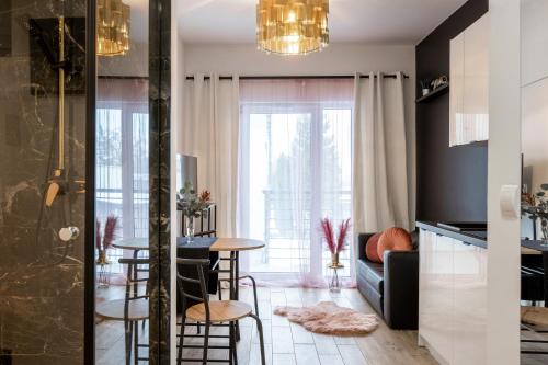 kuchnia i salon ze stołem i krzesłami w obiekcie Wyjątkowy apartament z prysznicem pośrodku na wyjątkowe wieczory w Łodzi